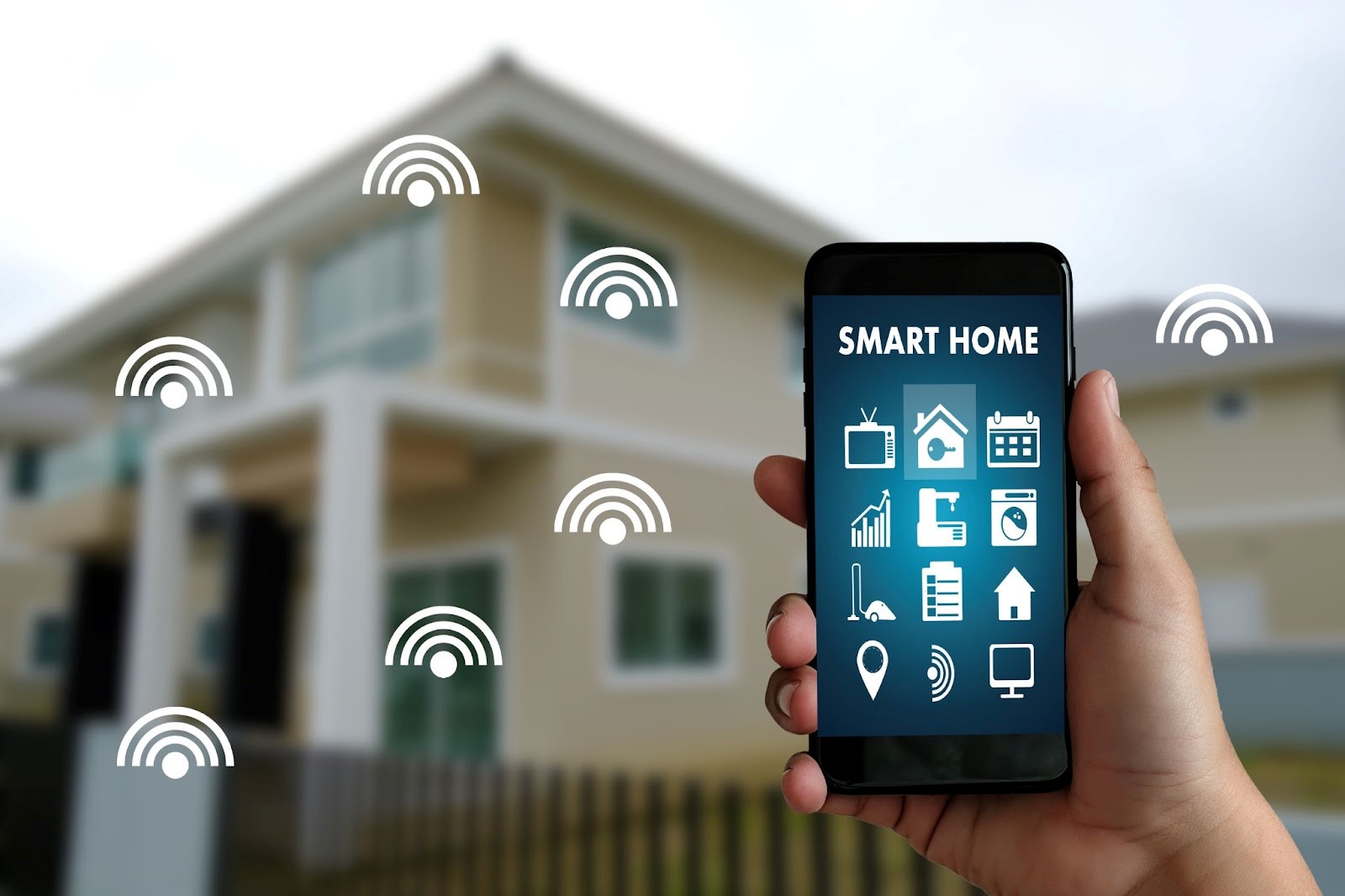 Person holding a smart phone with a smart home app in front of their house