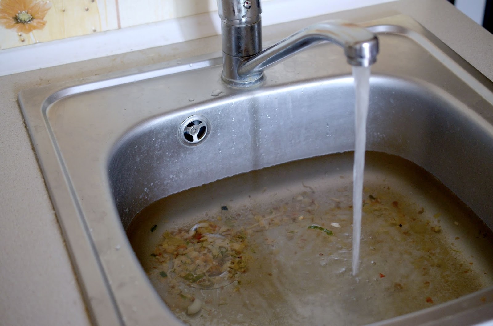 Too much food in the garbage disposal has caused a clogged kitchen sink