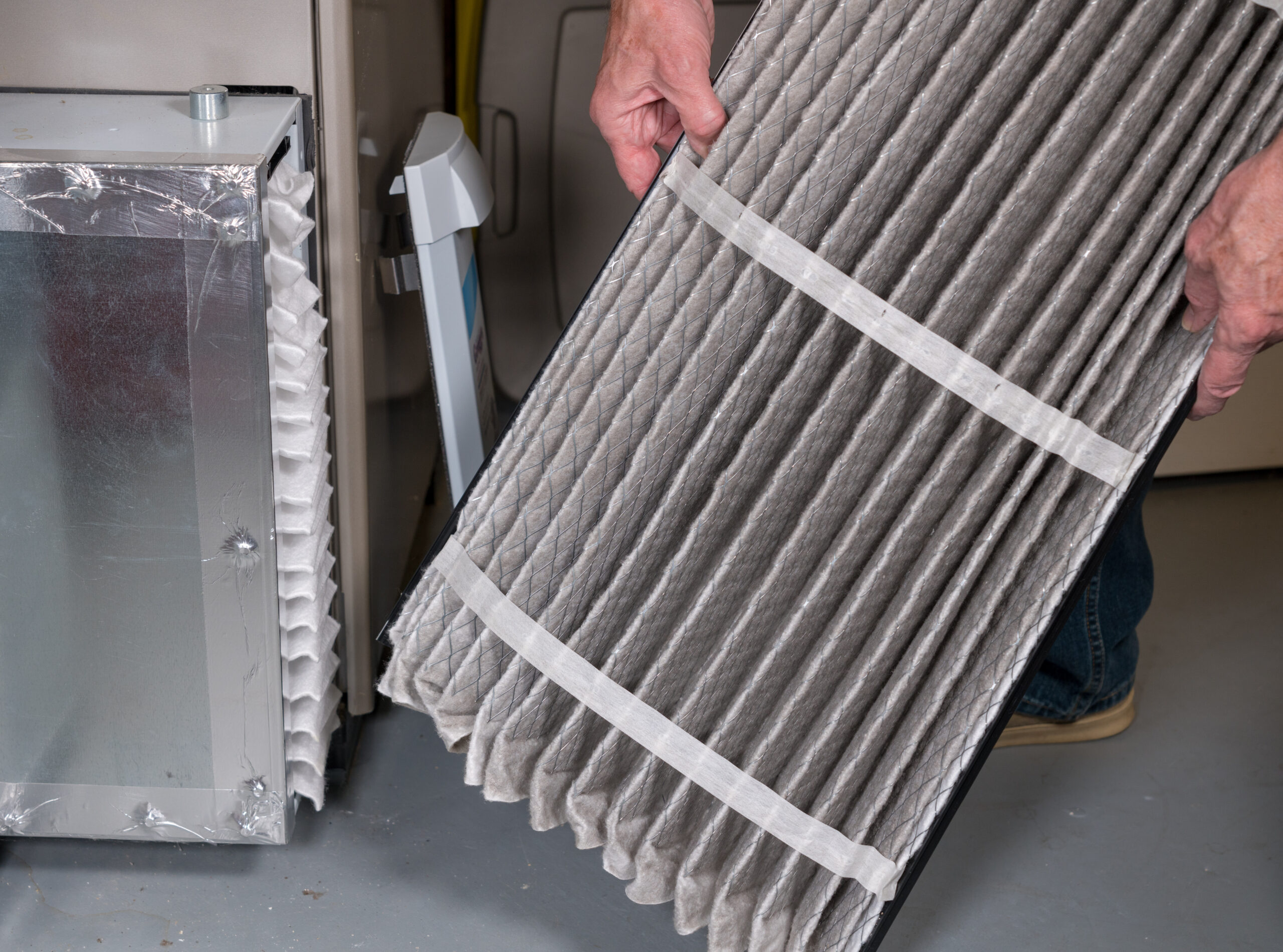 HVAC technician replacing an old, pleated HVAC filter