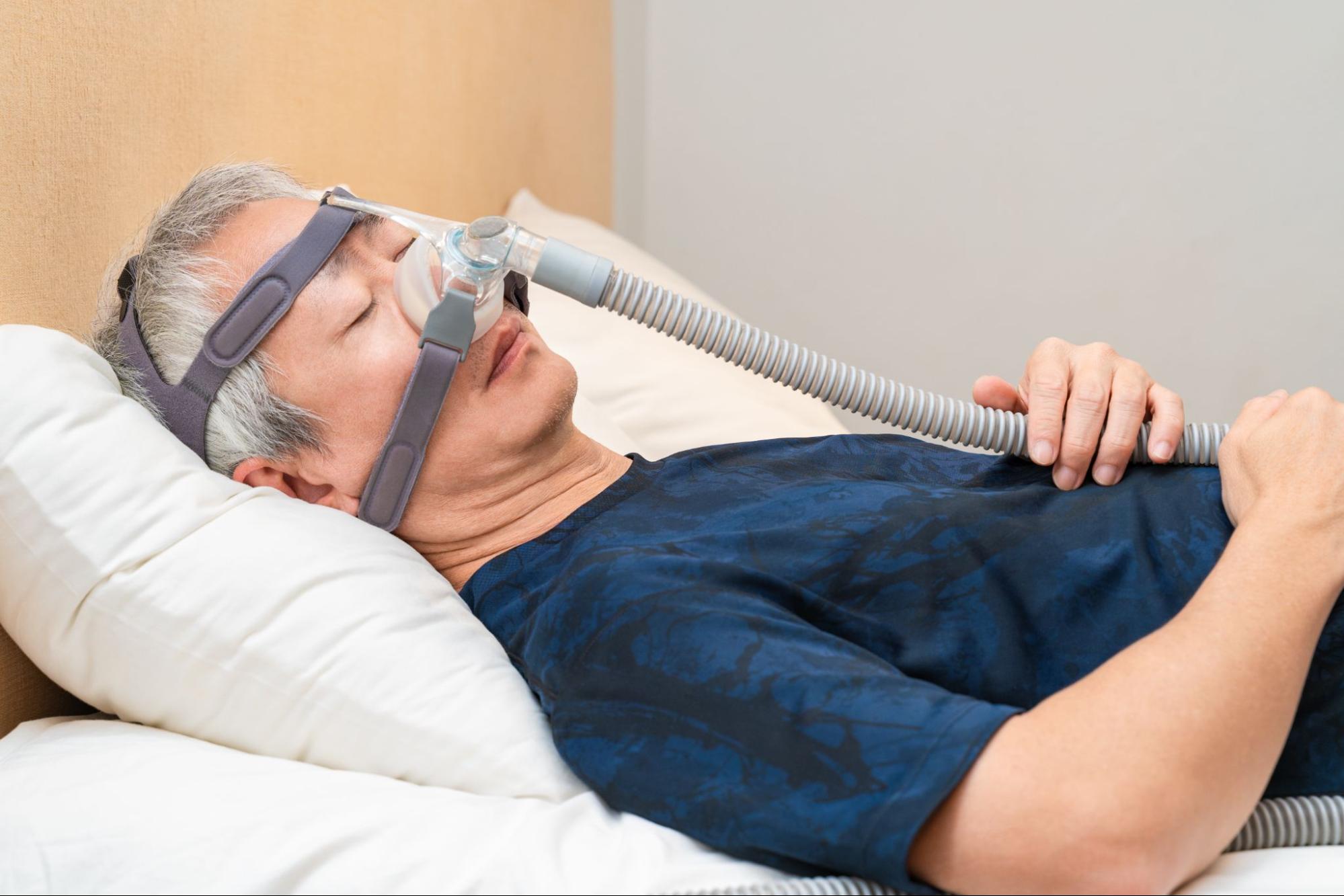 Middle age man wearing CPAP headgear during his sleep
