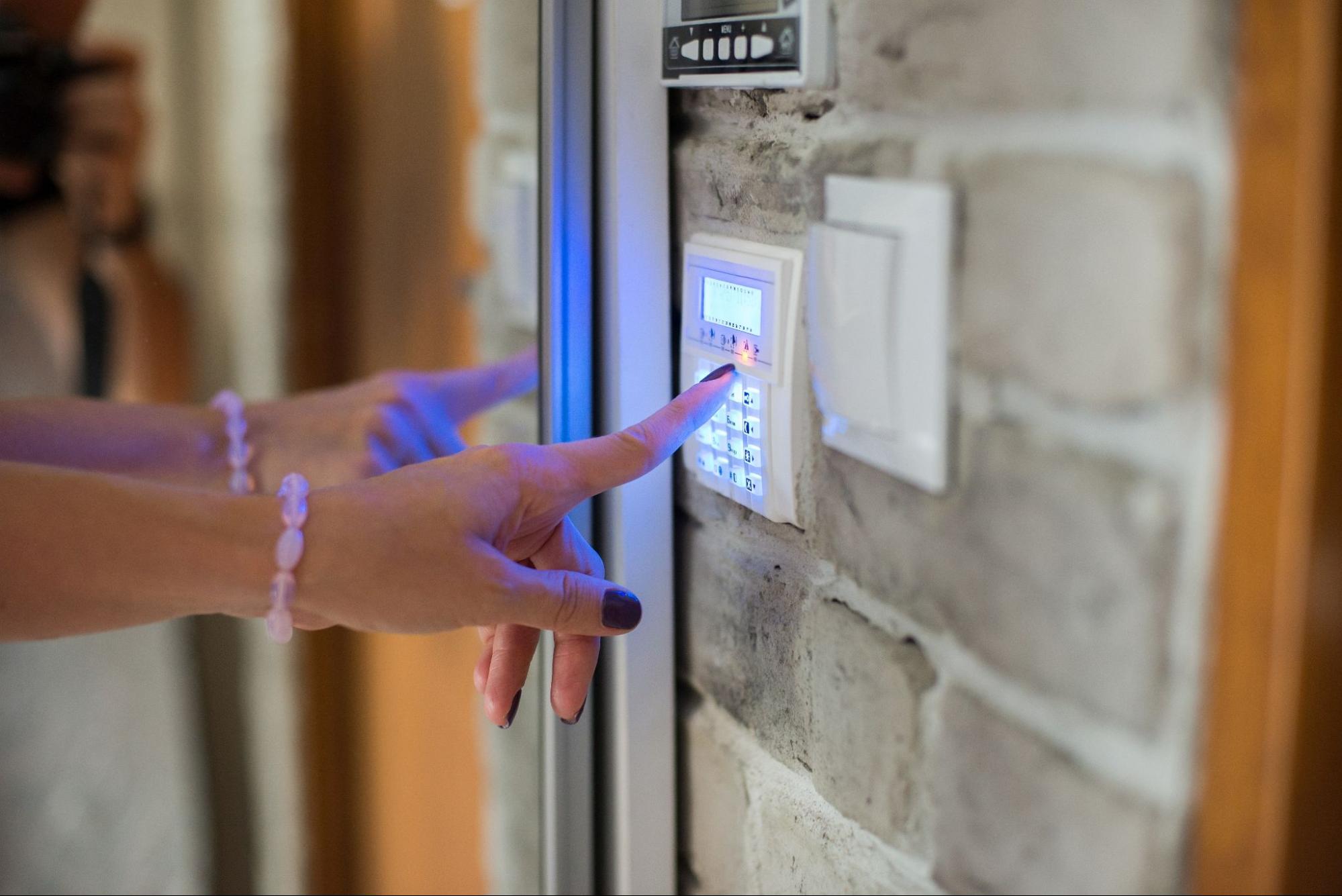 Woman entering password on home alarm keypad