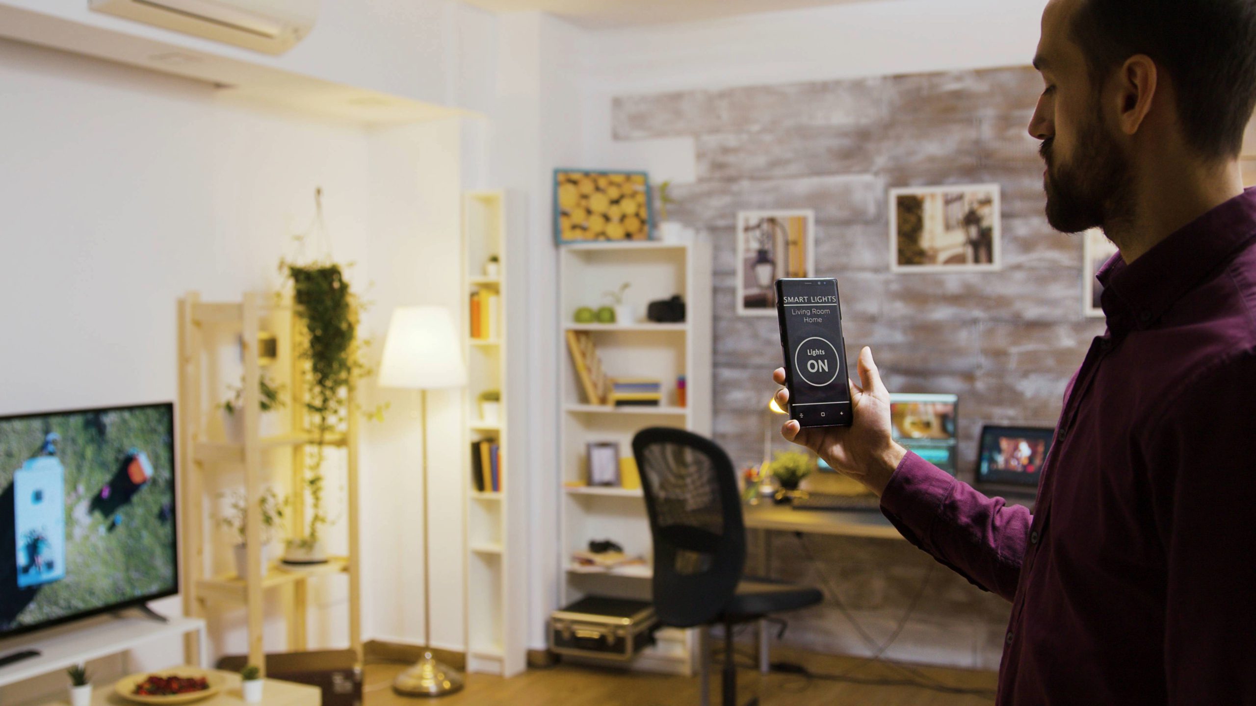 Smart home user controlling energy-efficient lighting with smartphone app in a connected living room.